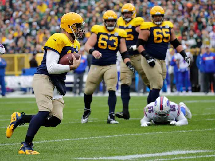 Green Bay Packers quarterback Aaron Rodgers runs past Buffalo Bills defenders.